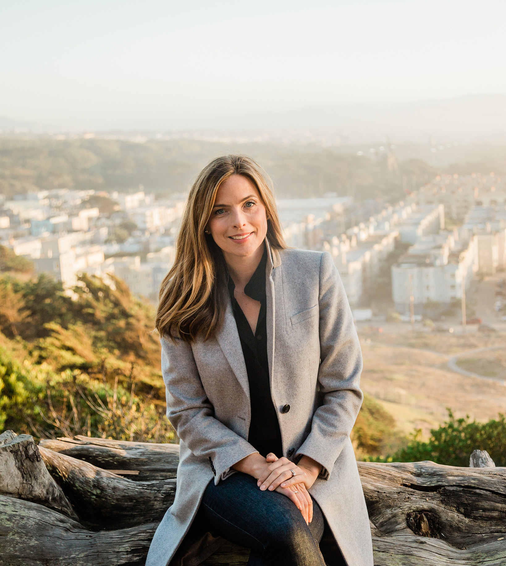 View of Shannon Hughes seated outside with San Francisco visible in the background