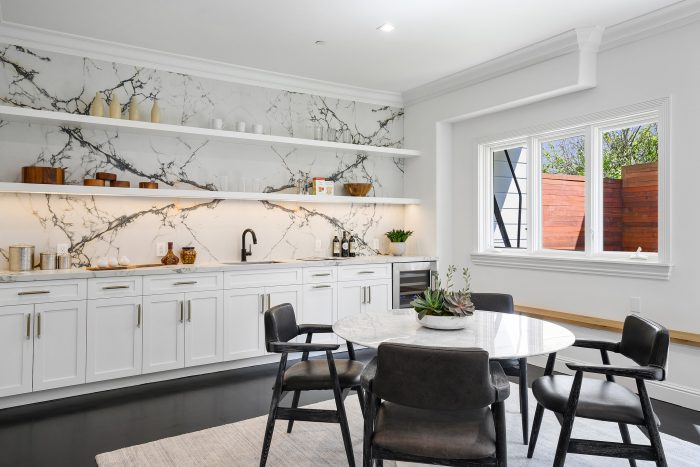 View of the kitchen showing white cabinets and an eat-in dining area