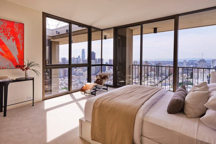 999 Green st penthouse bedroom with full plate glass walls and view of SF skyline