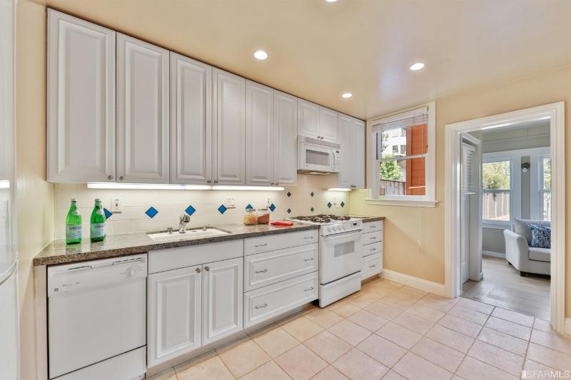 Kitchen with tile floor and white appliances 