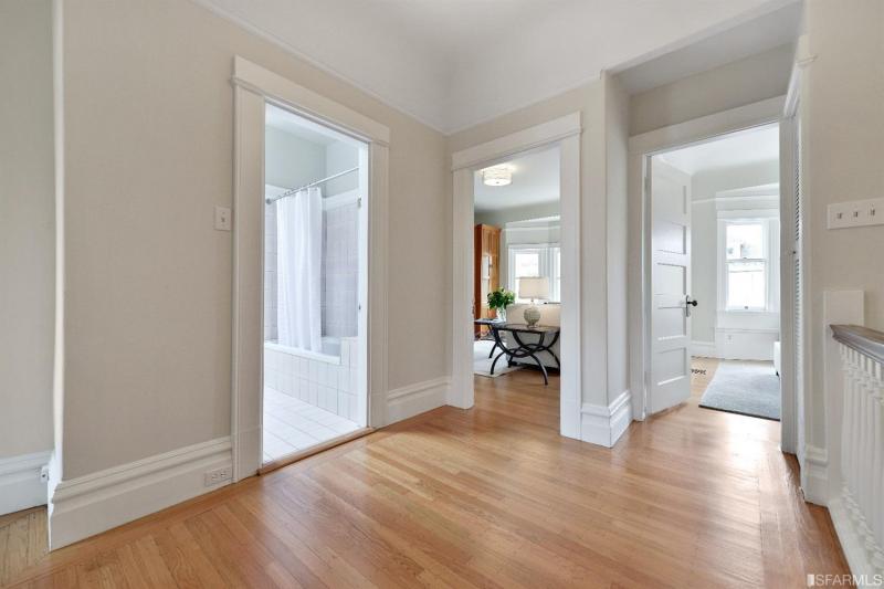 Hallway with wood floors and pale tan walls