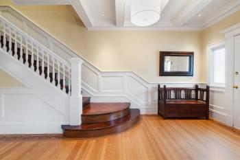 View of interior wood stairs with white railing 