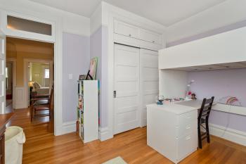 View of pale purple bedroom, showing a closet