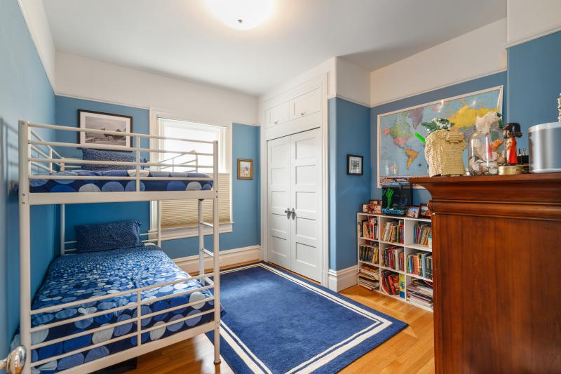View of a blue bedroom with wood floors