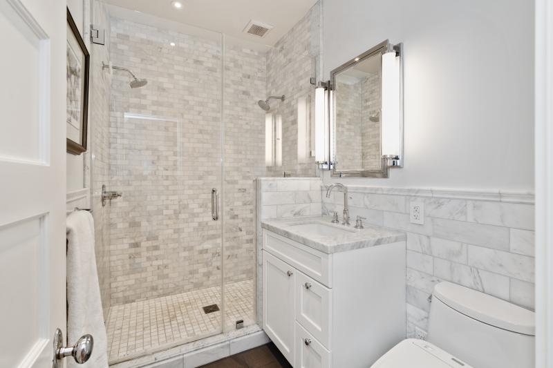 View of a white bathroom with a glass-front shower