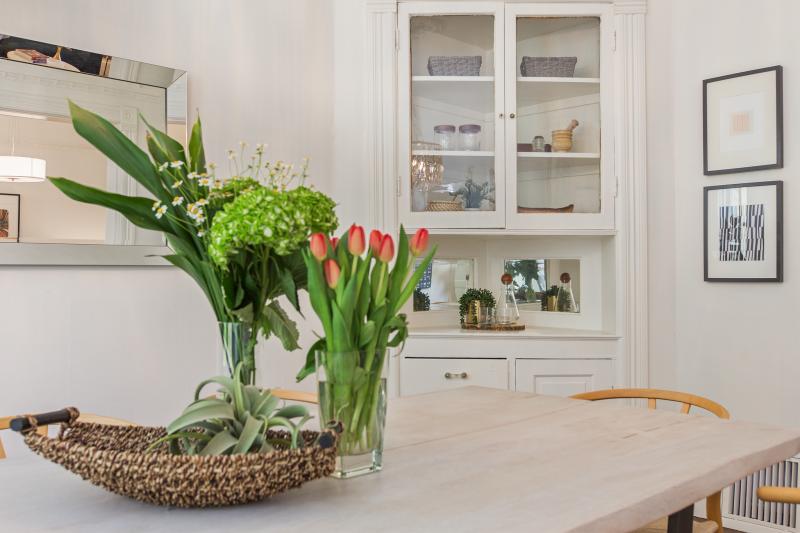 A table with fresh tulips is featured along with white built-in cabinetry 