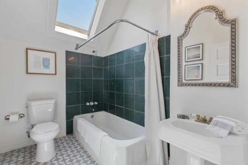 View of a bathroom with high ceilings an a skylight over the bath