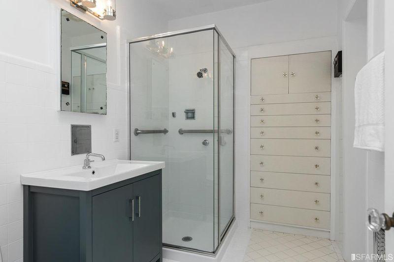 A bathroom with built-in storage and glass shower at 2832 Union Street