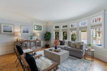 Living room of 233 Judah street, showcasing five large windows and wood floors
