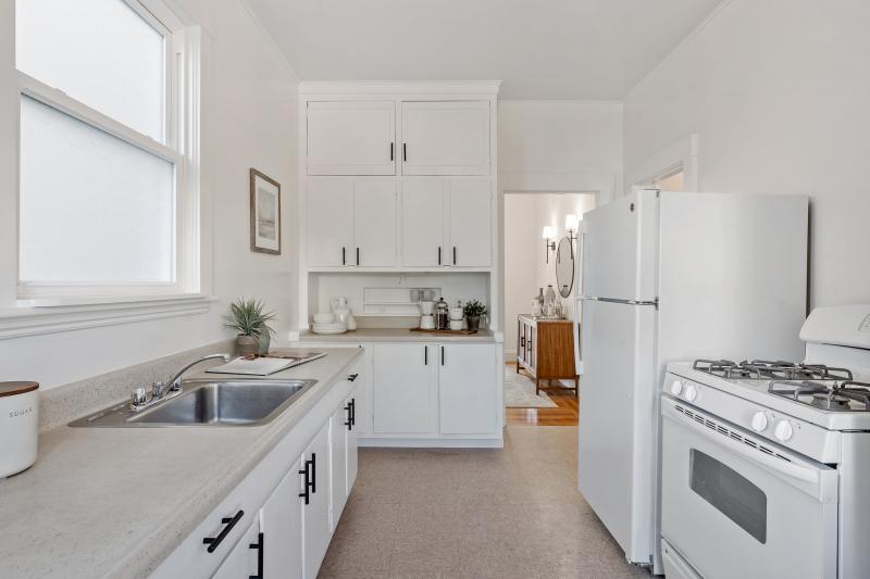 View of the kitchen showing white cabinets