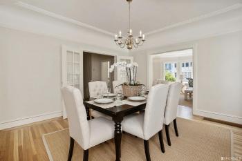 Formal dining room, featuring wood floors and a chandelier 