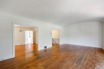 View of a large room with wood floors and two doorways 