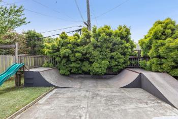 View of the back yard with a skate ramp