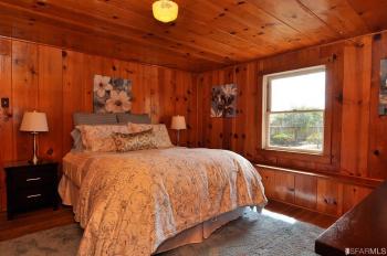 View of bedroom three, featuring wood paneling and ceiling 