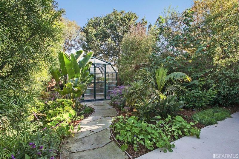 View of a stone path leading to a greenhouse 