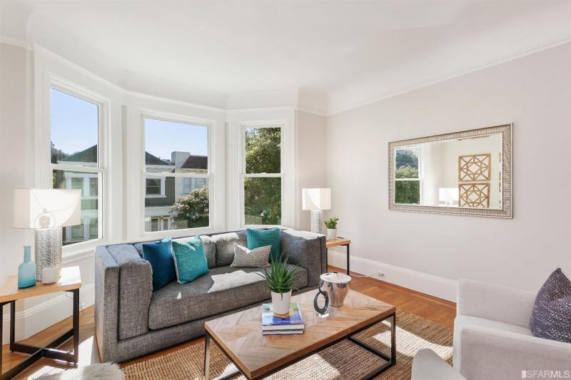 View of the couch positioned beneath three large windows