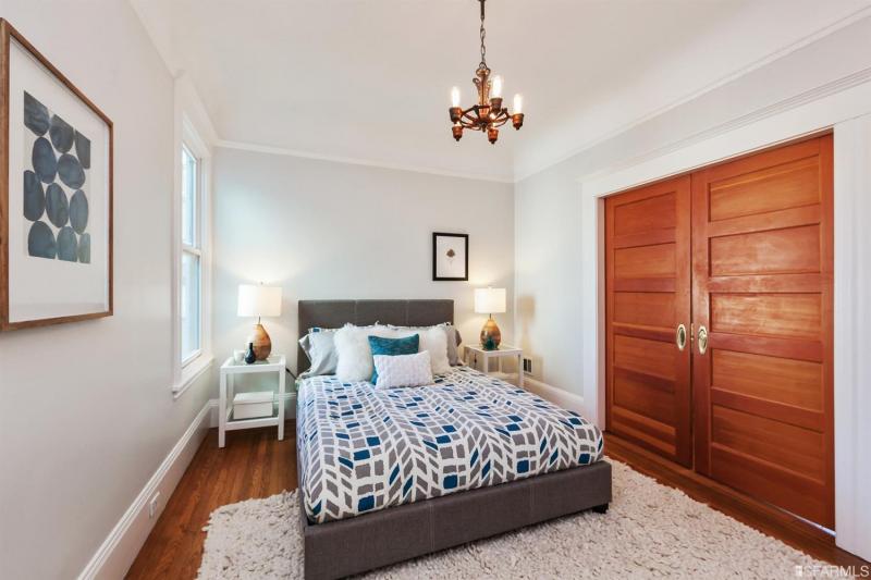 View of bedroom one with the wood pocket-doors closed