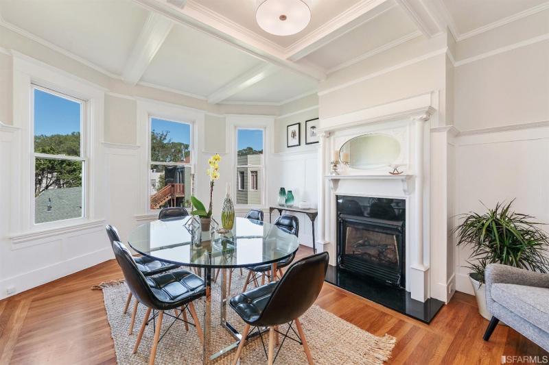 Formal dining area with wood floors and a fireplace