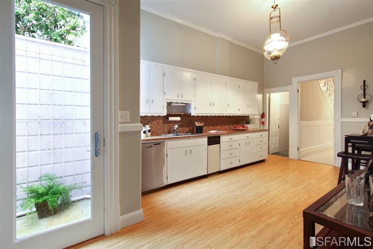 View of the kitchen at 1815 Laguna Street, showing white cabinets and wood floors