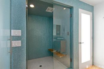 View of large walk-in shower with glass doors